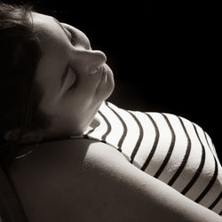 Close-up portrait of baby girl over black background