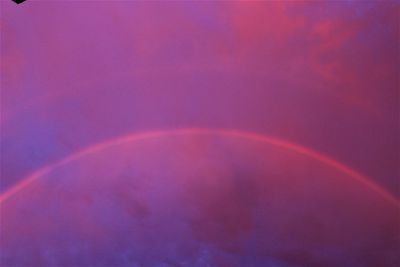 Low angle view of rainbow against sky at sunset