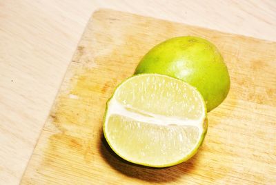 Close-up of halved lime on wooden table