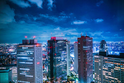 Illuminated buildings against sky at night