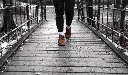 Low section of person walking on footbridge