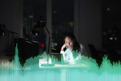 Young businesswoman working in office at night