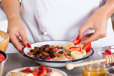 Midsection of chef preparing food in commercial kitchen