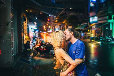 Young couple in illuminated city at night