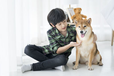 Full length of boy sitting on sofa