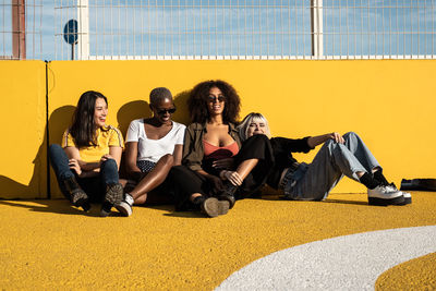 Cheerful young multiracial female students enjoying pastime on stadium