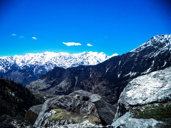 Scenic view of snowcapped mountains against blue sky