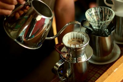 Close-up of hand holding coffee cup on table