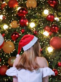 Rear view of woman with christmas tree