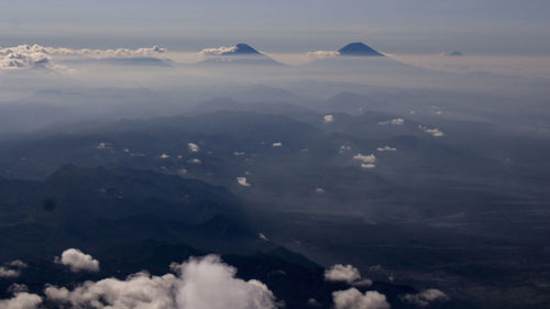 Aerial view of mountains against sky during foggy weather