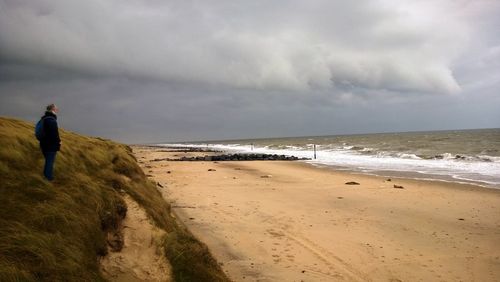Man standing on beach against sky