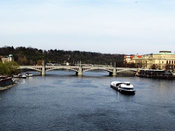Bridge over river in city against sky