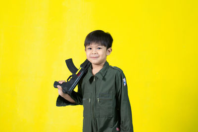 Portrait of smiling man standing against yellow wall