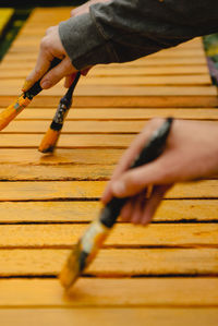 Close-up of person hand on wooden surface