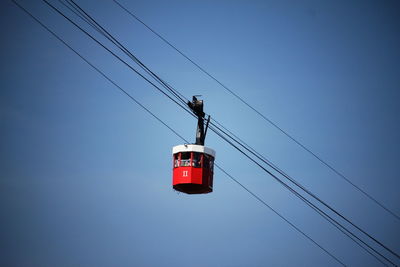 Low angle view of overhead cable car against sky