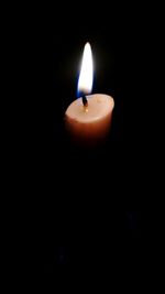 Close-up of burning candle in darkroom