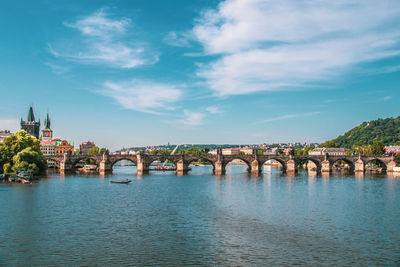 Bridge over river against cloudy sky