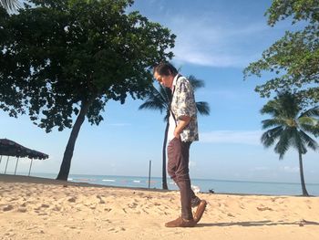 Full length of young woman on beach against sky