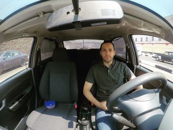 Portrait of man sitting in car