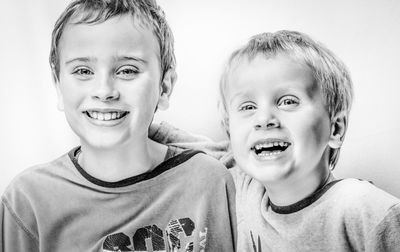 Close-up portrait of happy boy against white background