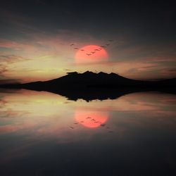 Reflection of clouds in sea at sunset