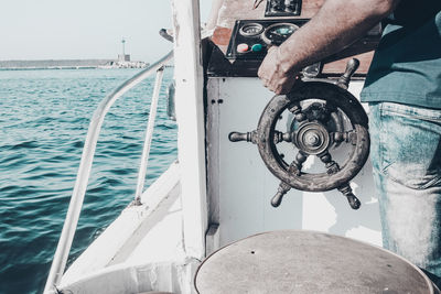 Close-up of hand on boat sailing in sea