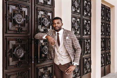 Portrait of young man standing at home