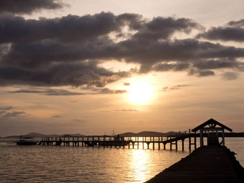 Pier over sea against sky during sunset