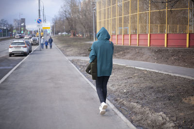 Rear view of man on street in city during winter