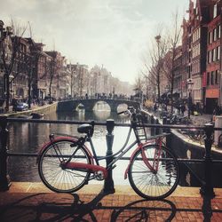 Bicycle by building in city against sky