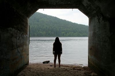 Rear view of woman overlooking calm lake