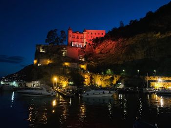 Illuminated buildings against sky at night