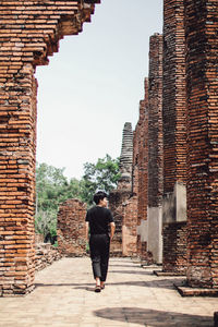 Rear view of man standing against building