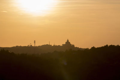 Silhouette of temple building against sky during sunset