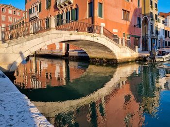 Bridge over canal amidst buildings in city