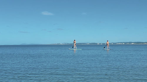 People on sea against sky