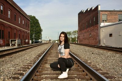 Portrait of young man standing on railroad station