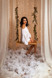 Portrait of young woman sitting on snow