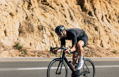 Rear view of man riding bicycle on mountain