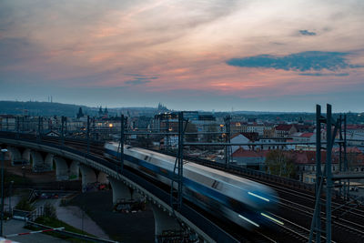 High angle view of train in city against sky during sunset