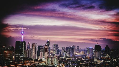 View of city lit up at sunset