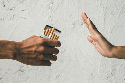 Close up hands of person refusing to smoke cigarette. negative attitude to smoking. quitting smoking
