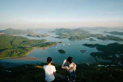 Rear view of people photographing landscape