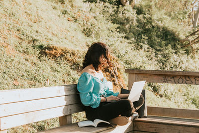 Full length of woman sitting on mobile phone