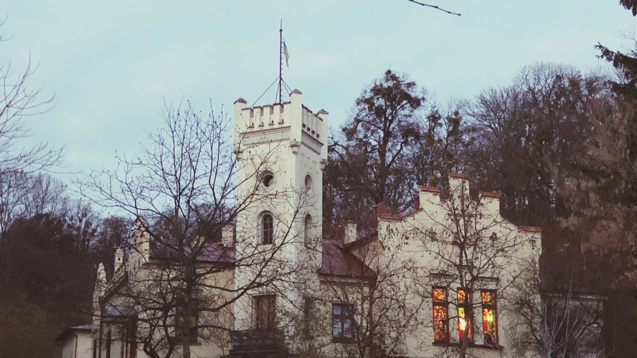 BARE TREES BY HISTORIC BUILDING AGAINST SKY