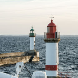 Lighthouse by sea against sky