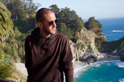 Fashionable man standing against mcway falls at beach