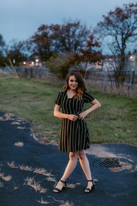 Portrait of smiling young woman standing on tree