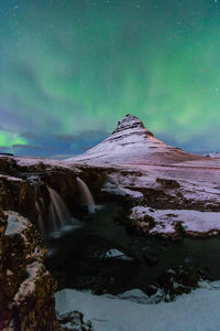 Scenic view of snowcapped mountain against sky at night