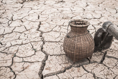 High angle view of wicker urn on cracked land